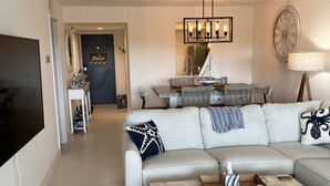 Ein modernes Wohnzimmer mit einem großen Sofa, einem Couchtisch und einem Deckenventilator.