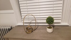 A wooden table with a gold-colored object and a small potted plant.