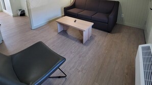 A living room with a brown sofa, a wooden coffee table, and a black chair. - Ski Mountain Lodge (Gatlinburg)