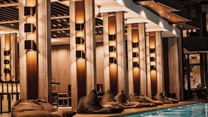 Zona de piscina con asientos y columnas.