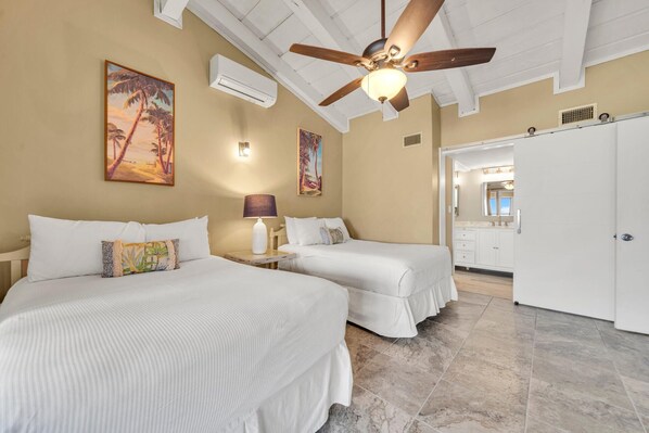 A hotel room with two beds, a ceiling fan, and artwork on the walls. - Beach Service! Private Beach, Chateau La Mer 13E! (Destin)