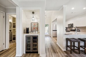 A modern kitchen with a built-in refrigerator, a coffee maker, and a wine cooler.
