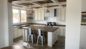 A kitchen with a central island, white cabinets, and a wooden ceiling. - Toledo Bend! Great Fishing with Great Sunsets! (Many)