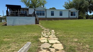 A single-story house with a stone pathway leading to a wooden deck. - Toledo Bend! Great Fishing with Great Sunsets! (Many)