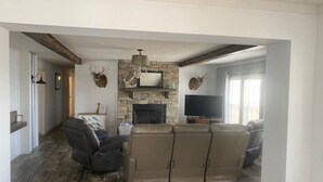 A living room with a stone fireplace, a large leather sofa, and mounted deer heads. - Toledo Bend! Great Fishing with Great Sunsets! (Many)