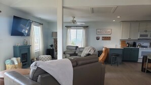A modern living room with a sofa, a television, and a fireplace. - 500 feet to the Beach, Full house with Stocked Kitchen, Linens & Beach Supplies (Avon)