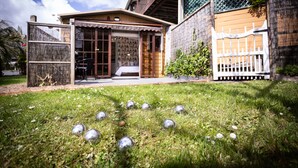 A house with a covered porch, a fenced yard, and several metallic balls on the grass. - A Fantastic Location
"Just a short walk down the footpath opposite to the Beach" (Snells Beach)