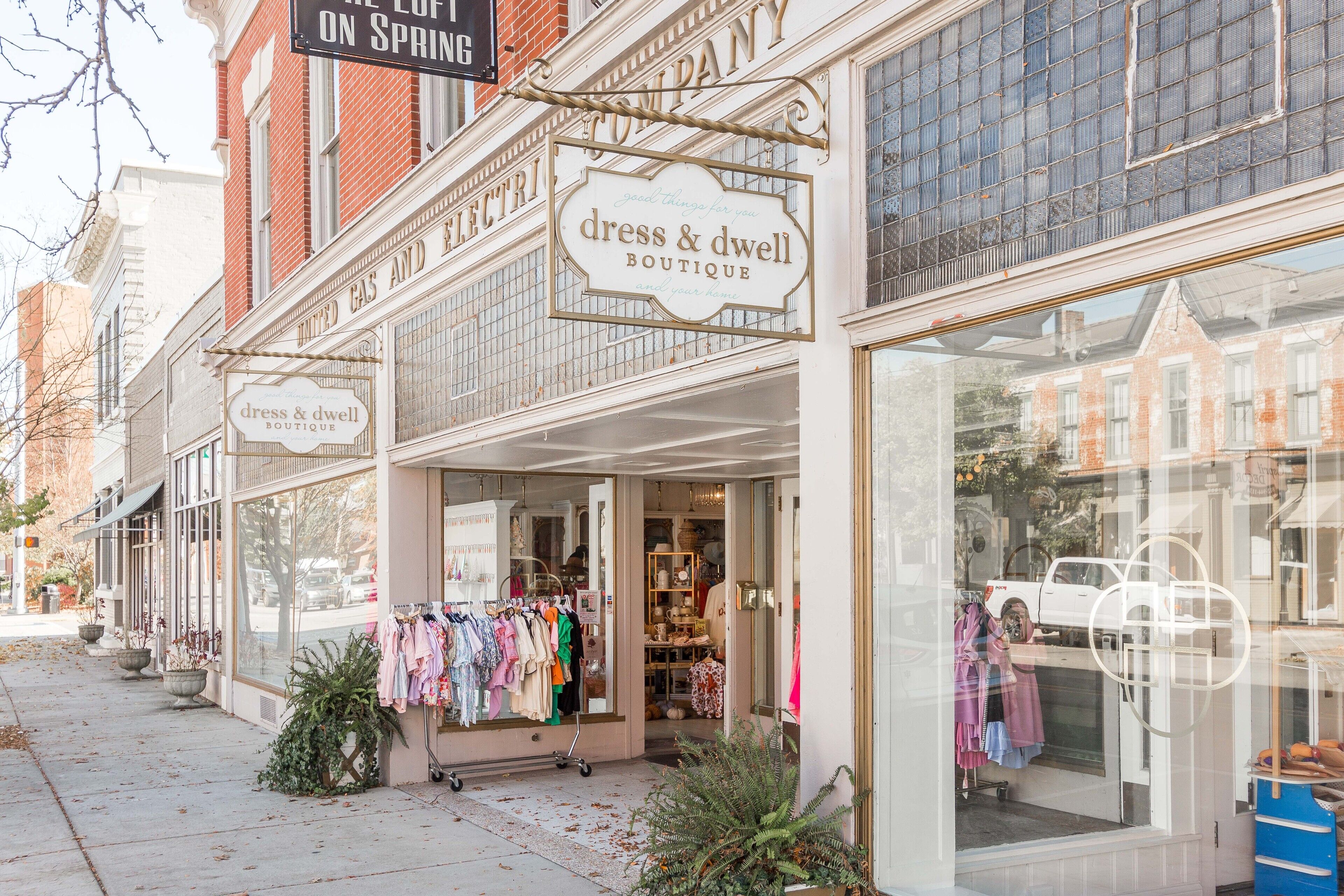 A storefront with a sign for a dress and home boutique.