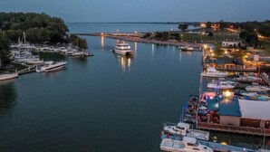 Un port de plaisance avec des bateaux amarrés, un grand yacht et un bateau amarré doté d’une zone abritée.