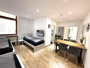 Habitación pequeña con cama, escritorio y silla.