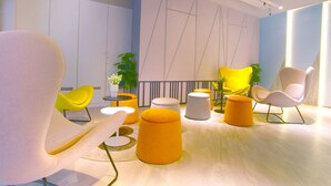 A modern lounge area with contemporary chairs, a small table, and a potted plant. - Fives Hotel DNP (Johor Bahru)