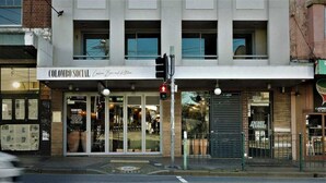 Un edificio con un letrero que dice "Colombo Social" y un restaurante llamado "Encore & Encore" en su interior.