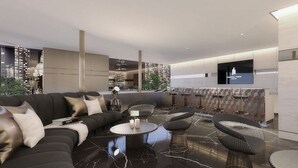 Ein stilvolles Wohnzimmer mit einer schwarzen Ledersofa, einem runden Couchtisch und Barhocker.