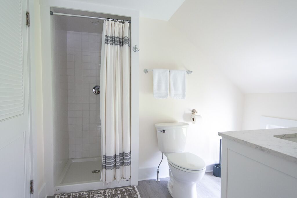 Ein Badezimmer mit Dusche, Toilette und Waschbecken.