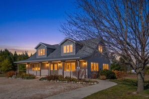 A two-story house with a covered porch, a garage, and a well-maintained lawn. - Perfect Retreat for 2 | Studio Above Bakery, Dogs! (Sister Bay)