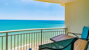 Een balkon met uitzicht op de oceaan, een tafel en een stoel.