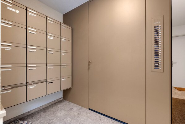 Une pièce de rangement avec des armoires métalliques et une grande porte de couleur beige.