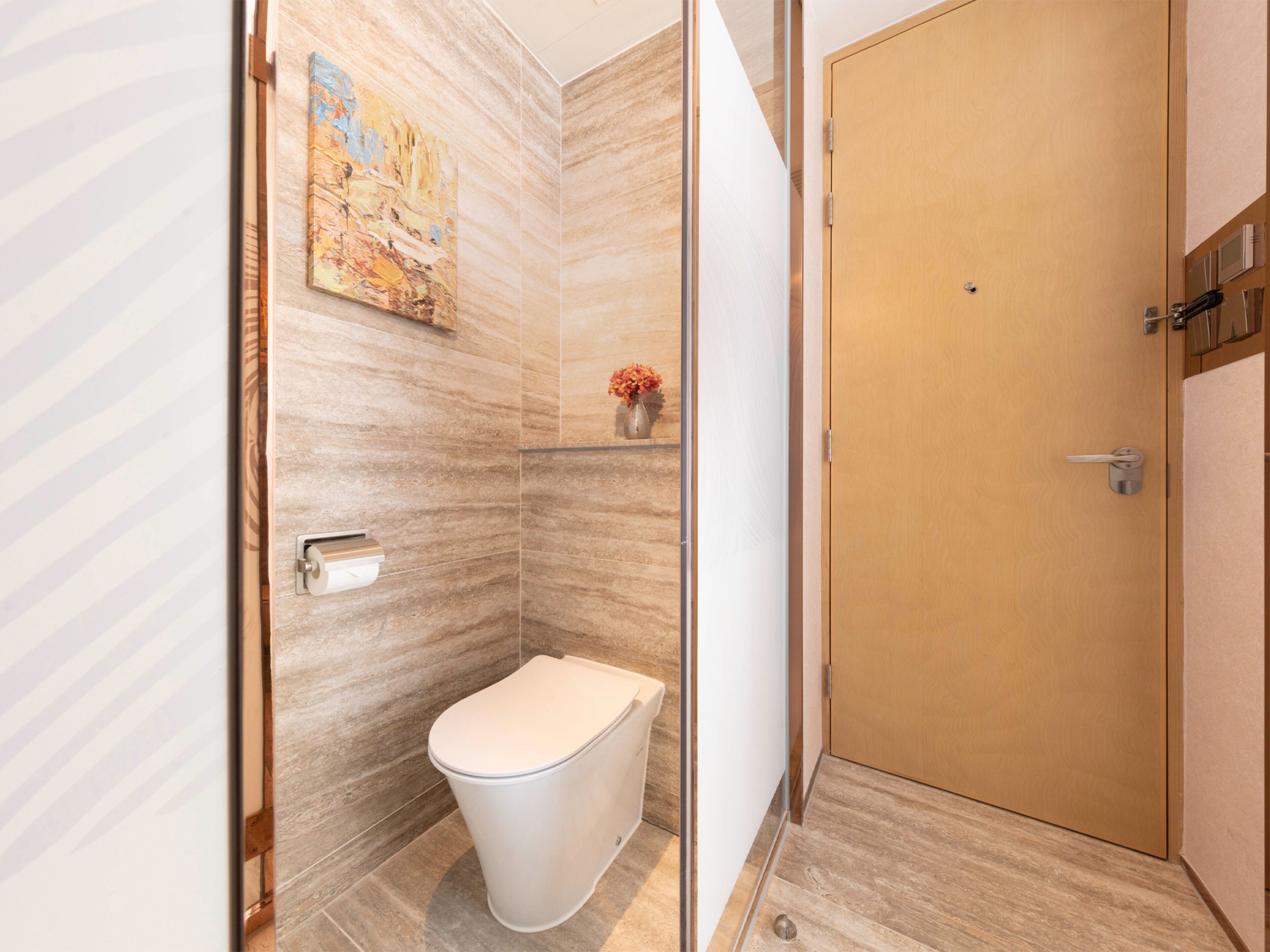 A modern bathroom with a toilet, a shower, and a wooden door.