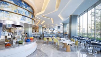 A modern restaurant with a curved counter, marble flooring, and large windows offering a view of the outdoors.