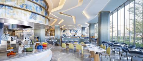 A modern restaurant with a curved counter, marble flooring, and large windows offering a view of the outdoors.