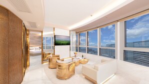 Una sala de estar moderna con un televisor grande, asientos cómodos y vista a la ciudad.