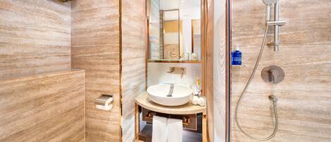 A modern bathroom with a large mirror, a sink, and a shower.