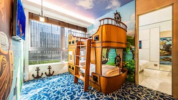 A child’s bunk bed with a ship-themed design, a large window with blinds, and a mural of a ship on the wall.
