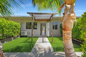 A house with a covered patio, a lawn, and a palm tree. - 2. Waterfront Key Largo Studio / Fish & Relax (Key Largo)