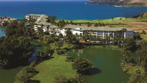 Un resort con varias edificaciones, un campo de golf y una gran extensión de agua.