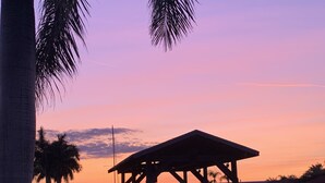 Un gazebo in legno su una riva tranquilla al tramonto.