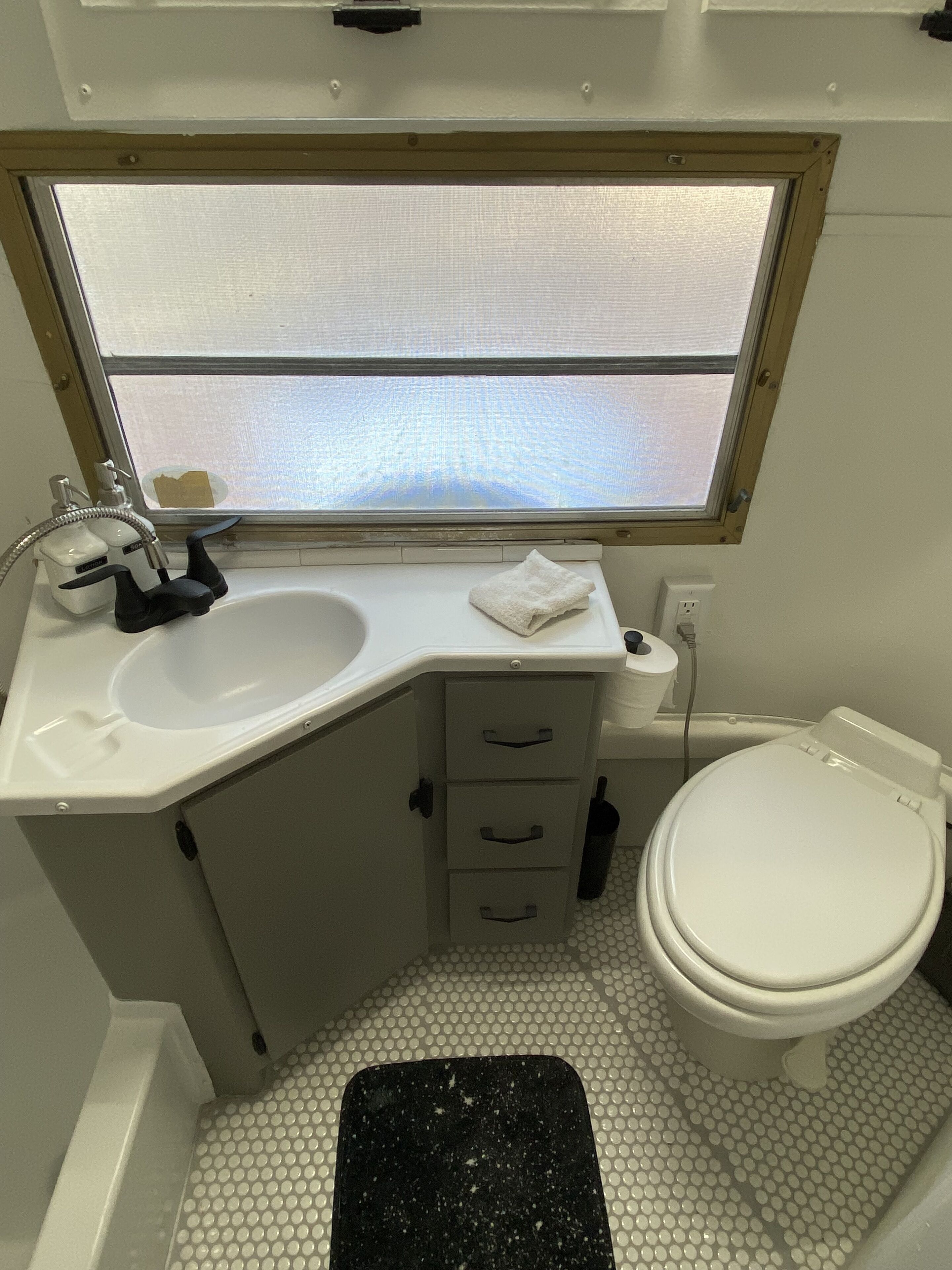 Ein kleines Badezimmer mit Waschbecken, Spiegel und Toilette.