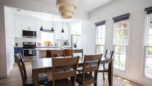 A modern kitchen with white cabinets, a central island, and pendant lighting.