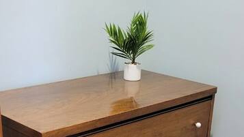 Een houten dressoir met vijf lades en een kleine potplant erop.