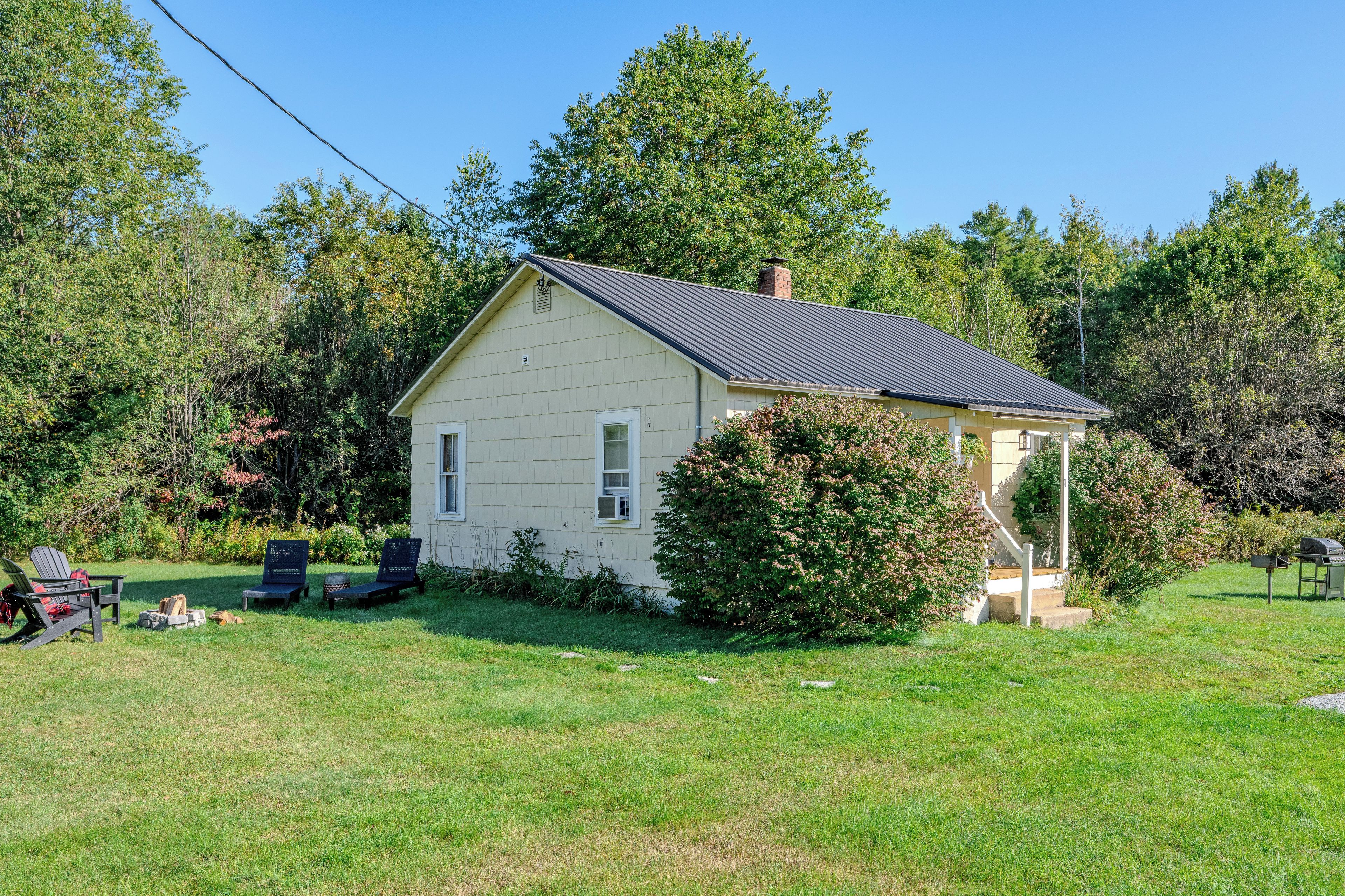 A single-story house with a gabled roof, a covered porch, and a small front yard.