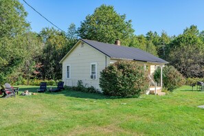 A single-story house with a gabled roof, a covered porch, and a small front yard.