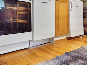 Una cocina compacta con refrigerador, un mueble de madera y una ventana con vistas.