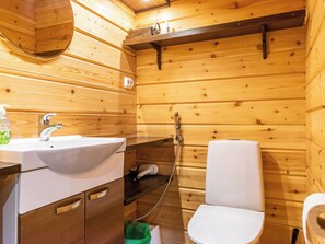 A wooden cabin bathroom with a sink, toilet, and shower. - Tulikettu 1 by Interhome (Pelkosenniemi)