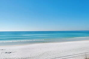 Ein Strand mit blauem Himmel und ruhiger See.