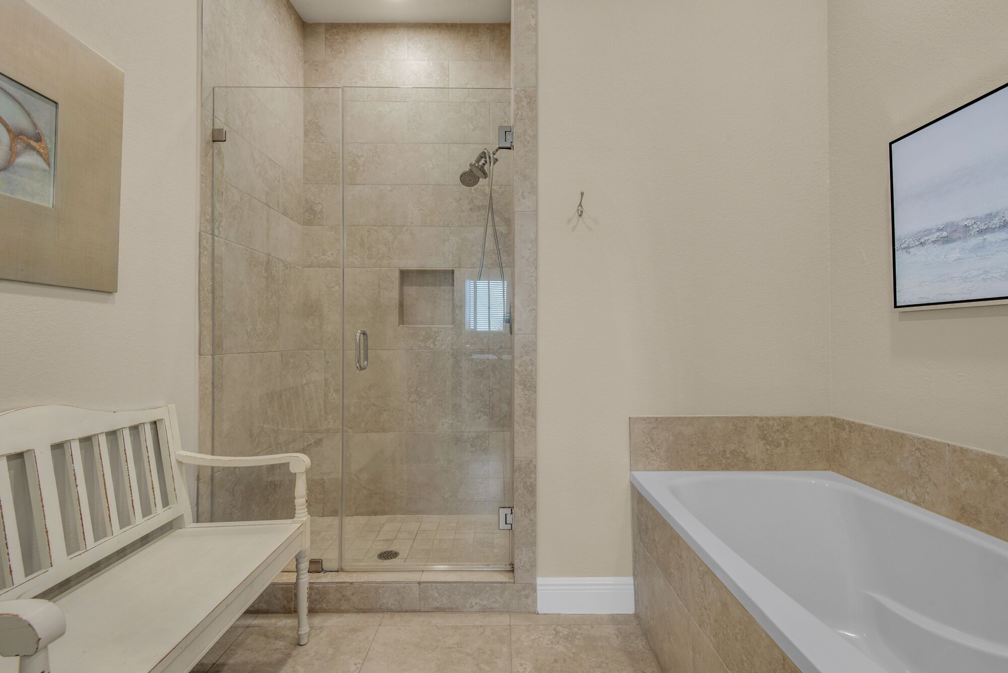 Une salle de bain avec une douche à l’italienne, une baignoire et un banc.