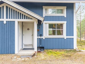 A two-story house with a front porch, a door with a wreath, and a window with shutters. - Oivanpyhä c 10 by Interhome (Pelkosenniemi)