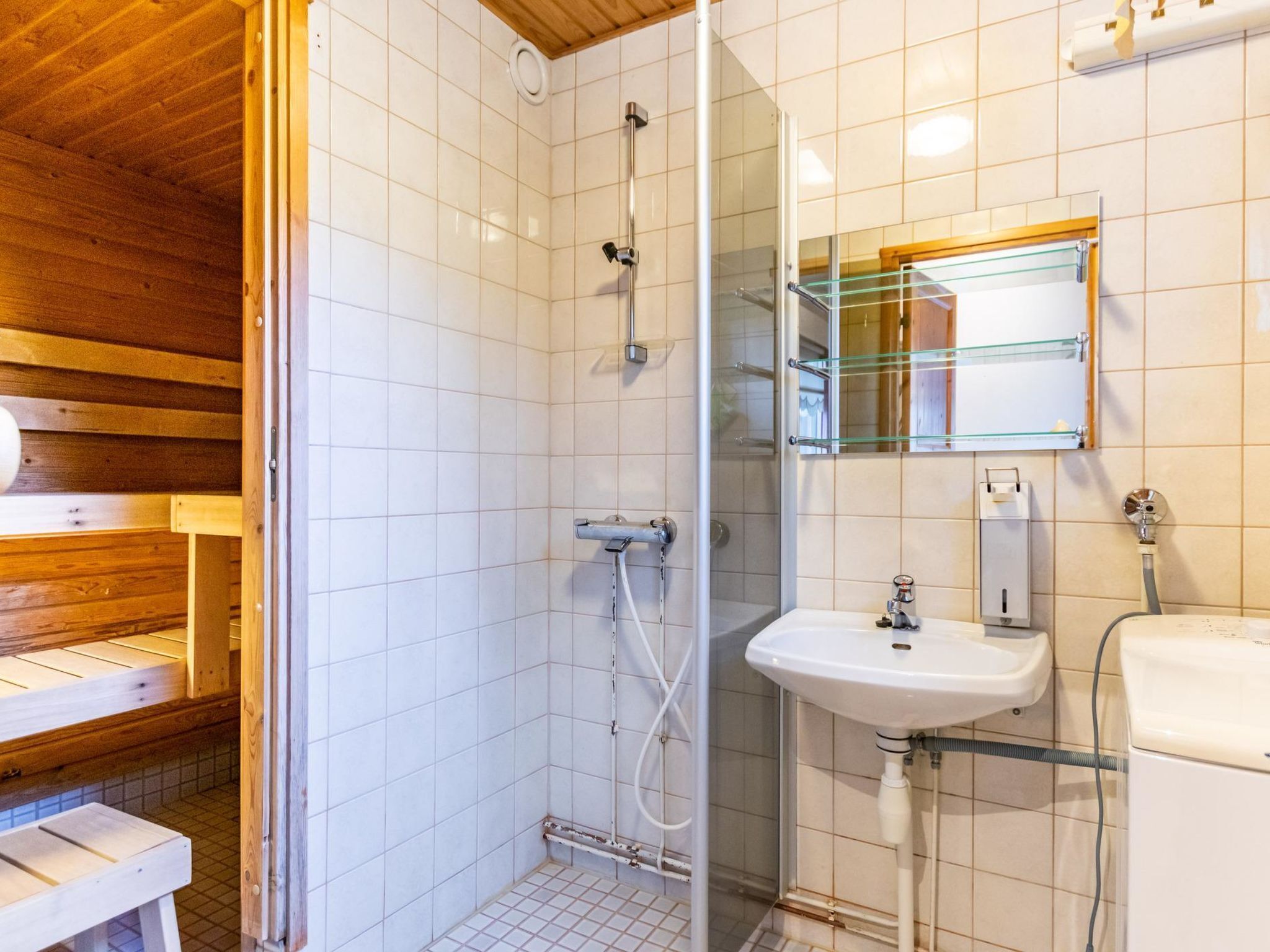 Ein Badezimmer mit Dusche, Waschbecken und Spiegel.