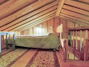 A room with a single bed, wooden walls, and a sloped ceiling. - Luppokero 1 by Interhome (Pelkosenniemi)