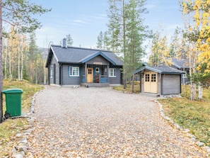 A cabin with a gravel driveway, surrounded by trees and a small shed. - Tunturikettu by Interhome (Pelkosenniemi)