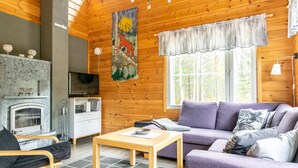 Ein gemütliches Blockhaus-Interieur mit Kamin, Sofa und einem Fuchs-Bild.