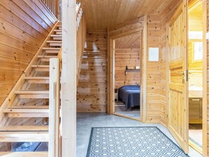 Puinen sisustus, jossa on portaikko, joka johtaa makuuhuoneeseen.