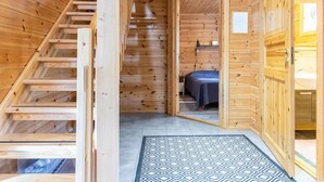 Ein Holzblock-Innenraum mit einer Treppe, die zu einem Schlafzimmer führt.