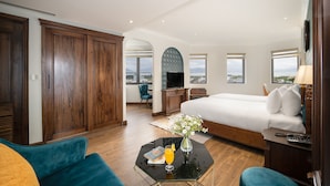 Una habitación de hotel con cama, escritorio, televisor y vistas a la ciudad.