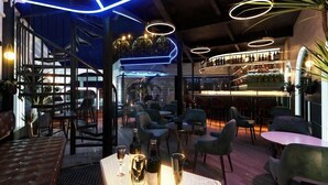 Zona de bar moderna con asientos, una escalera y una exhibición de vinos.