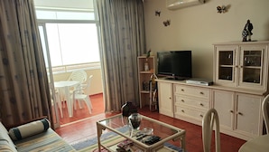 A living room with a sofa, coffee table, TV, and cabinets. - Varandas da Rocha 7 (Portimão)