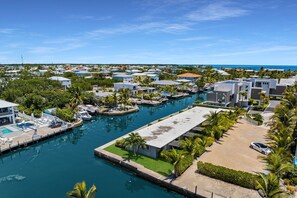 Un port de plaisance avec des bateaux amarrés, une piscine et un bâtiment doté d’un toit plat.